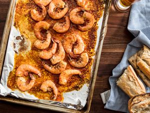 A foil-lined sheet pan of quick broiled shrimp cooked in beer and harissa.
