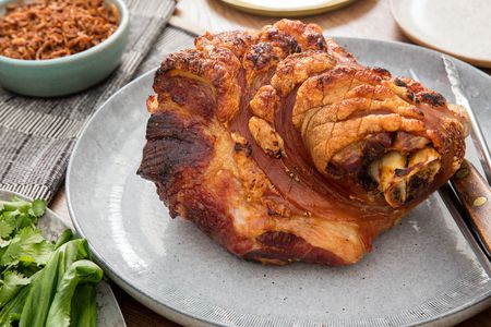 A Thai-inspired slow-roasted pork shoulder served on a gray platter.
