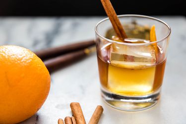 An old timber cocktail with whiskey, orange peel, and cinnamon sticks