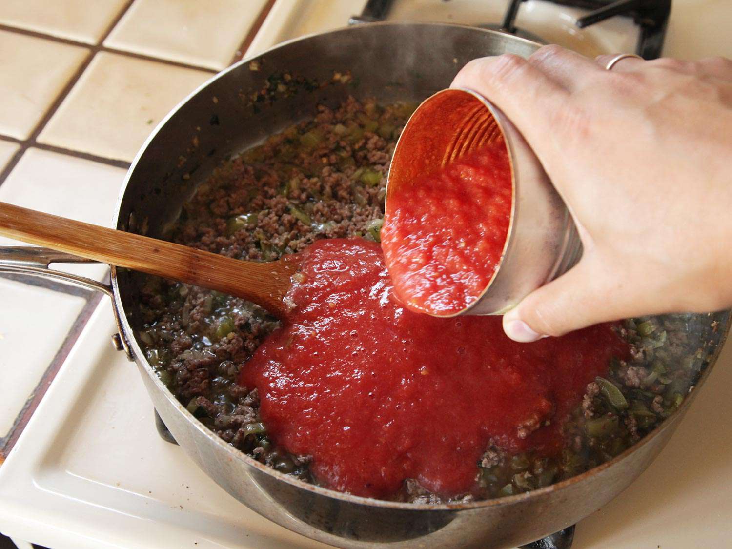 将一罐净化过的番茄加入锅中。
