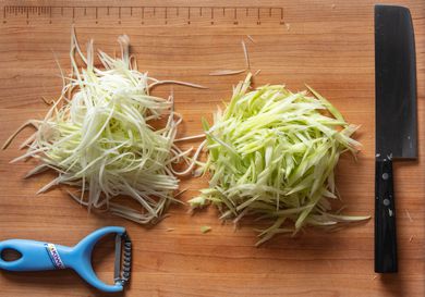 切菜板上用刀切和削皮切成丝的青木瓜