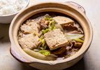 上一碗冷冻炖豆腐汤，配上猪肉、卷心菜和米粉，旁边还有米饭