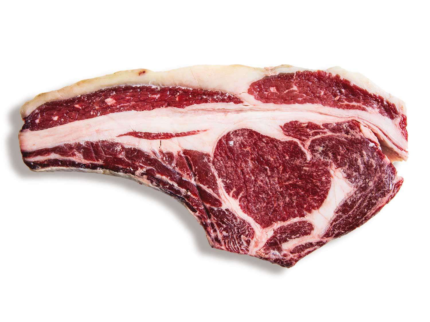 An uncooked ribeye steak on a white background