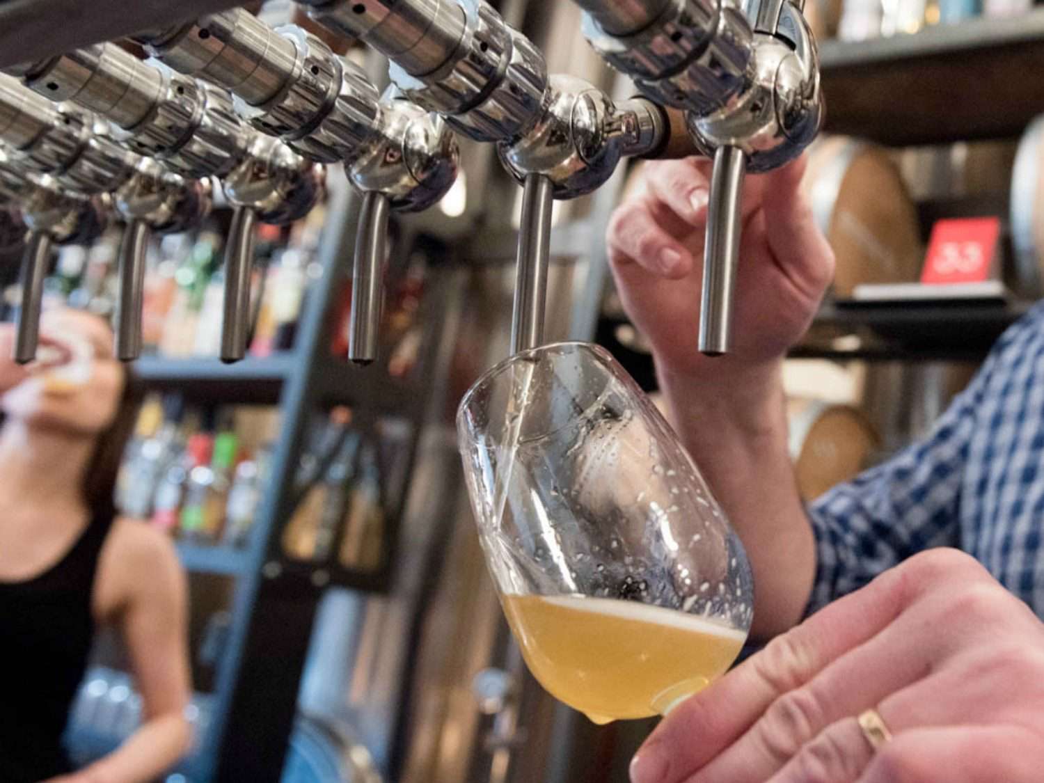 Pouring beer into a glass from a tap.