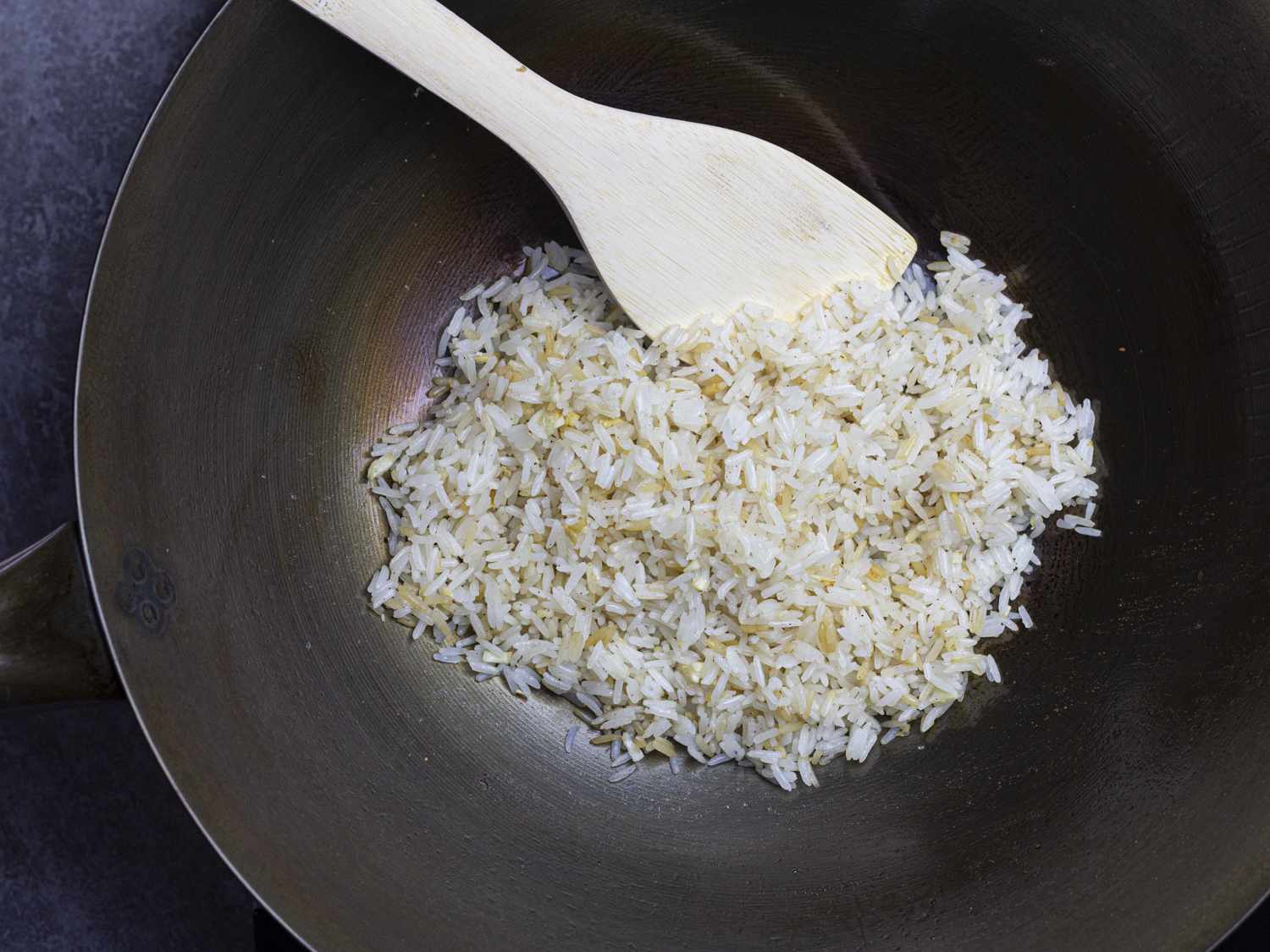 Garlic fried rice being cooked in a wok