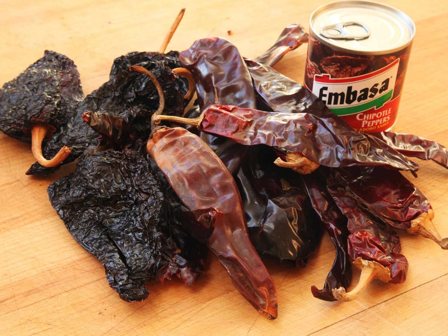 干瓜希罗，帕西拉，智利辣椒，加上一罐墨西哥辣椒，放在木砧板上腌肉。