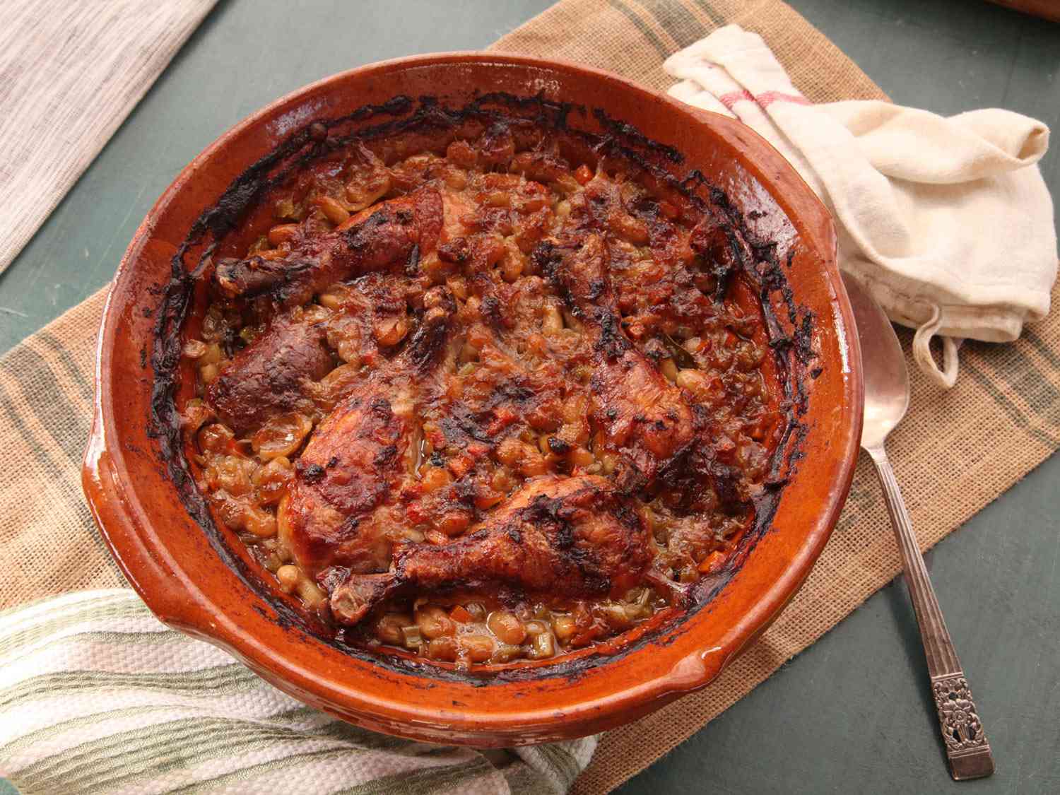 Baked cassoulet in an earthenware pot with a crispy, browned top.