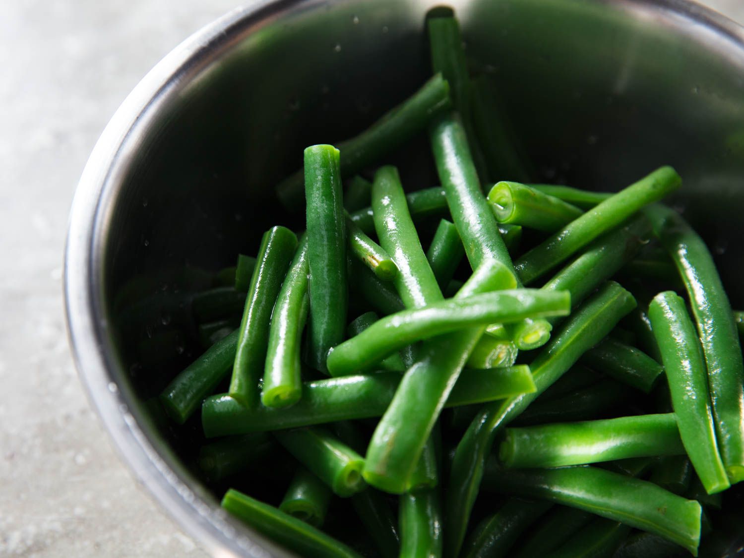 Blanched green beans in a metal bowl
