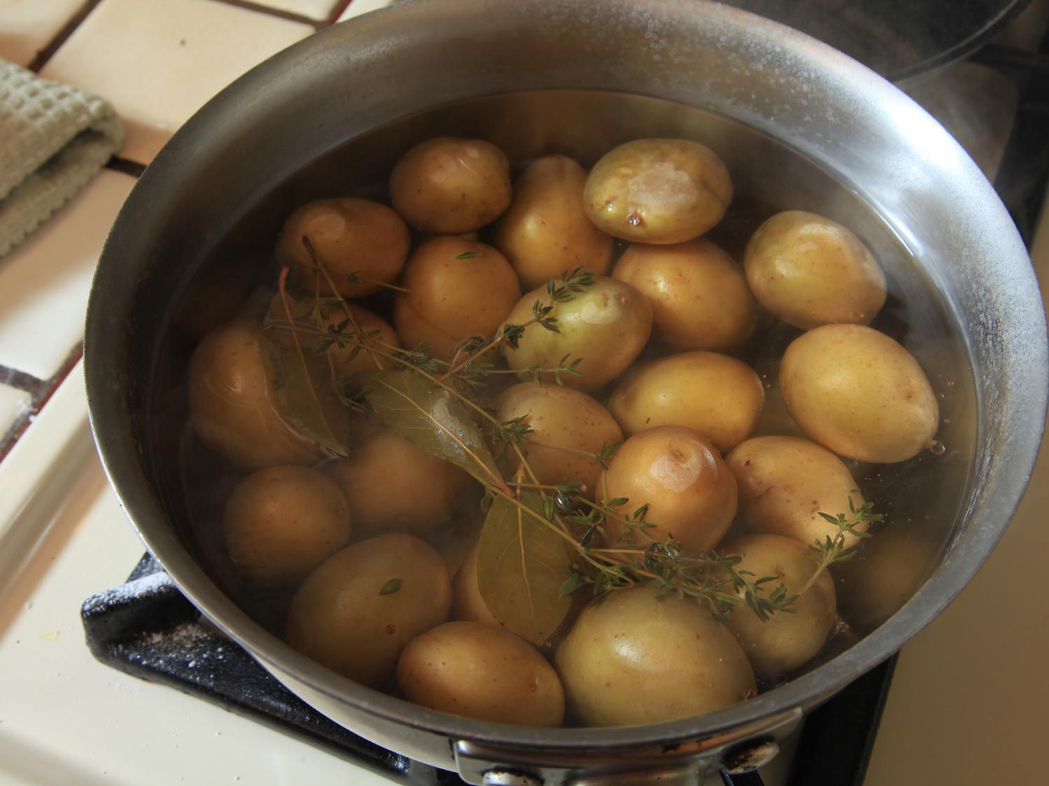 新鲜的百里香枝与小土豆浸泡在一壶水中