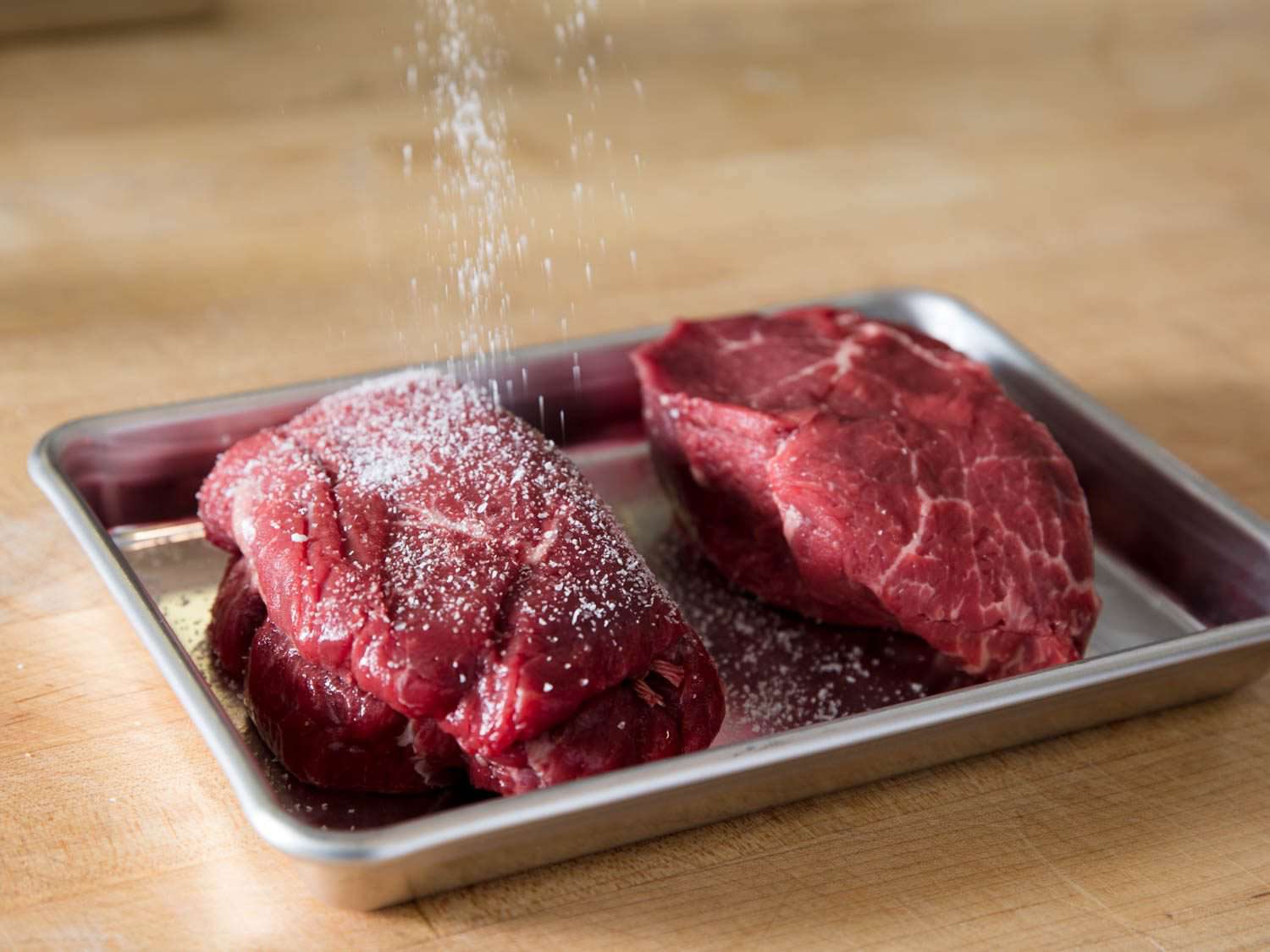 Seasoning beef on an eight-sheet pan