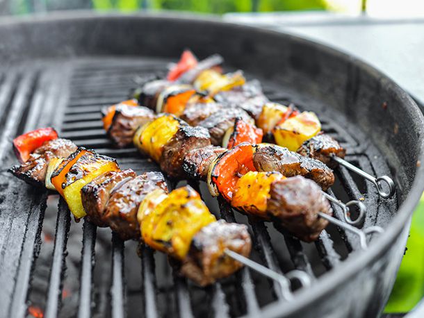 Charred kabobs on a charcoal grill.