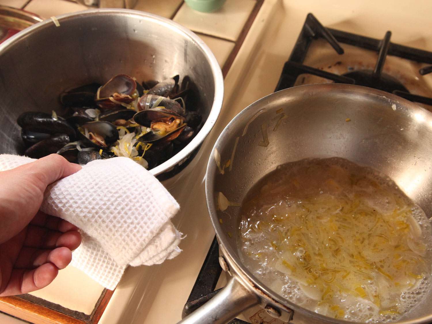 蒸熟的，打开的贻贝放在碗里备用。炖贻贝的锅还在煨着。