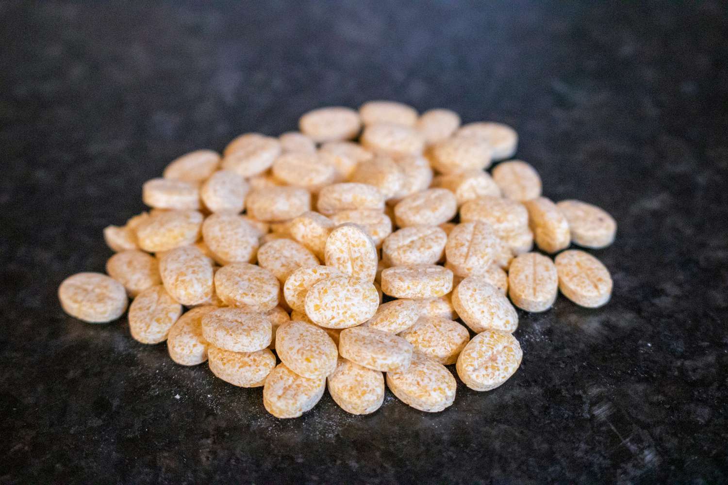 a handful of Grindz tablets on a black countertop