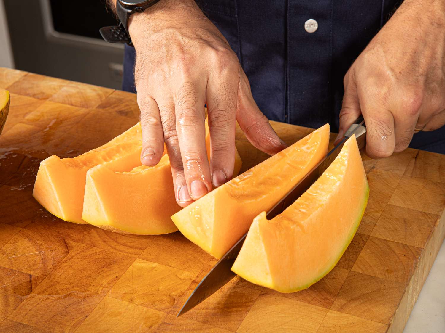 Overhead view of cutting melons into fourths