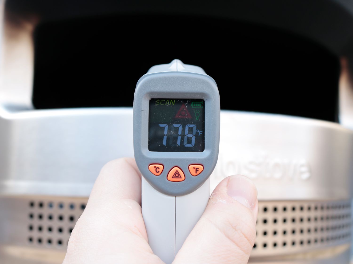 an infrared thermometer reads 776 degrees in a cooling pizza oven