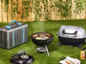 Three portable charcoal grills on a lawn