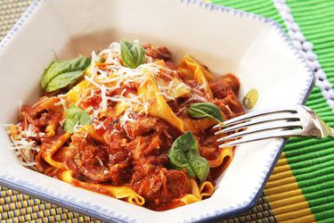 bowl of pasta with Neapolitan ragu garnished with basil leaves