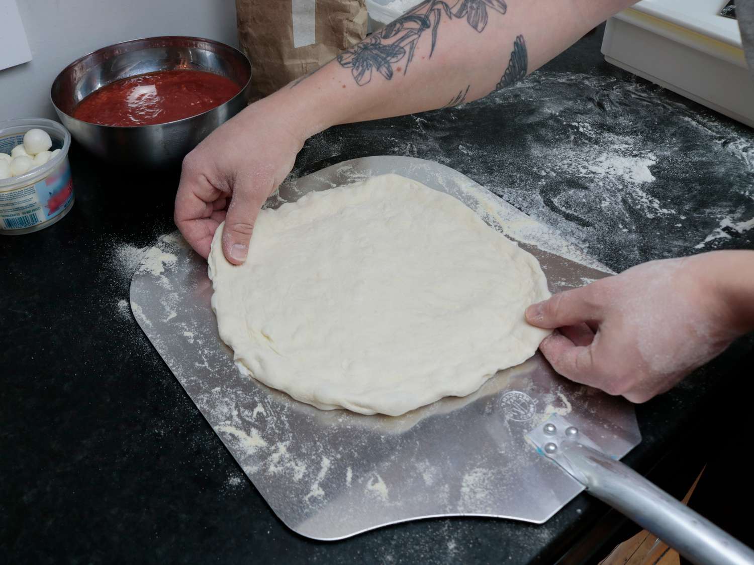 pizza dough stretched on a square peel