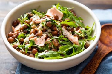 Closeup of salmon bean salad servied in a small white bowl.