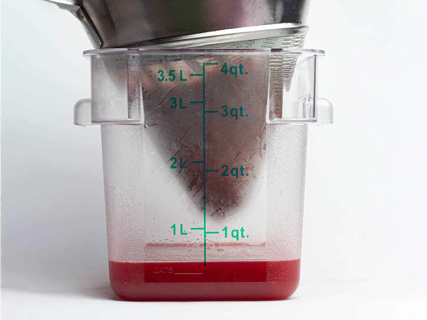 Straining syrup into a measuring cup