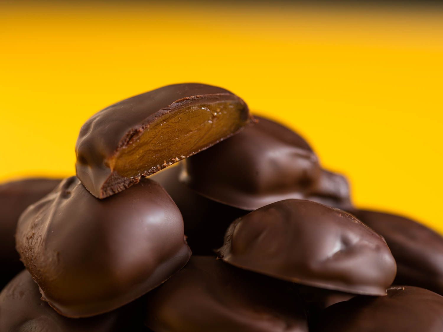 Closeup of homemade milk duds. One dud has been cut in half to reveal the caramel center.