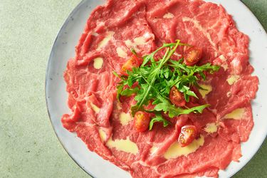 beef carpaccio garnished with tomato quarters