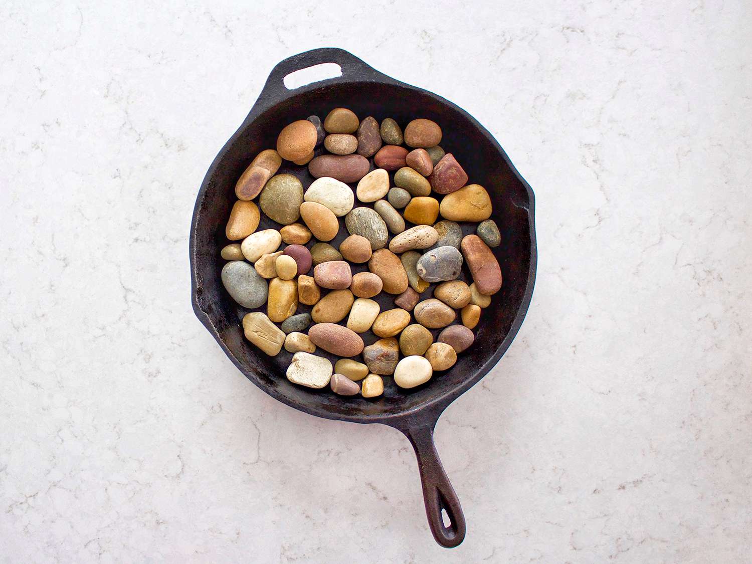 铸铁锅上铺着河中的岩石。