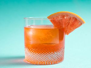 一款与众不同的内格罗尼、Aperol、Lillet和金酒鸡尾酒，杯沿上有一个柚子楔形。
