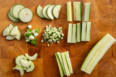 Overhead view of cucumbers cut in a bunch of different ways