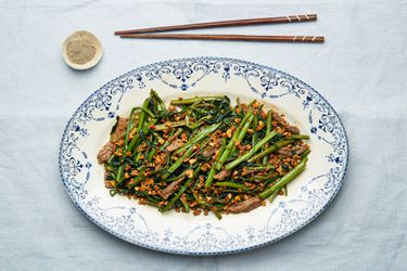 Overhead view of sauteed morning glory with beef on a plate