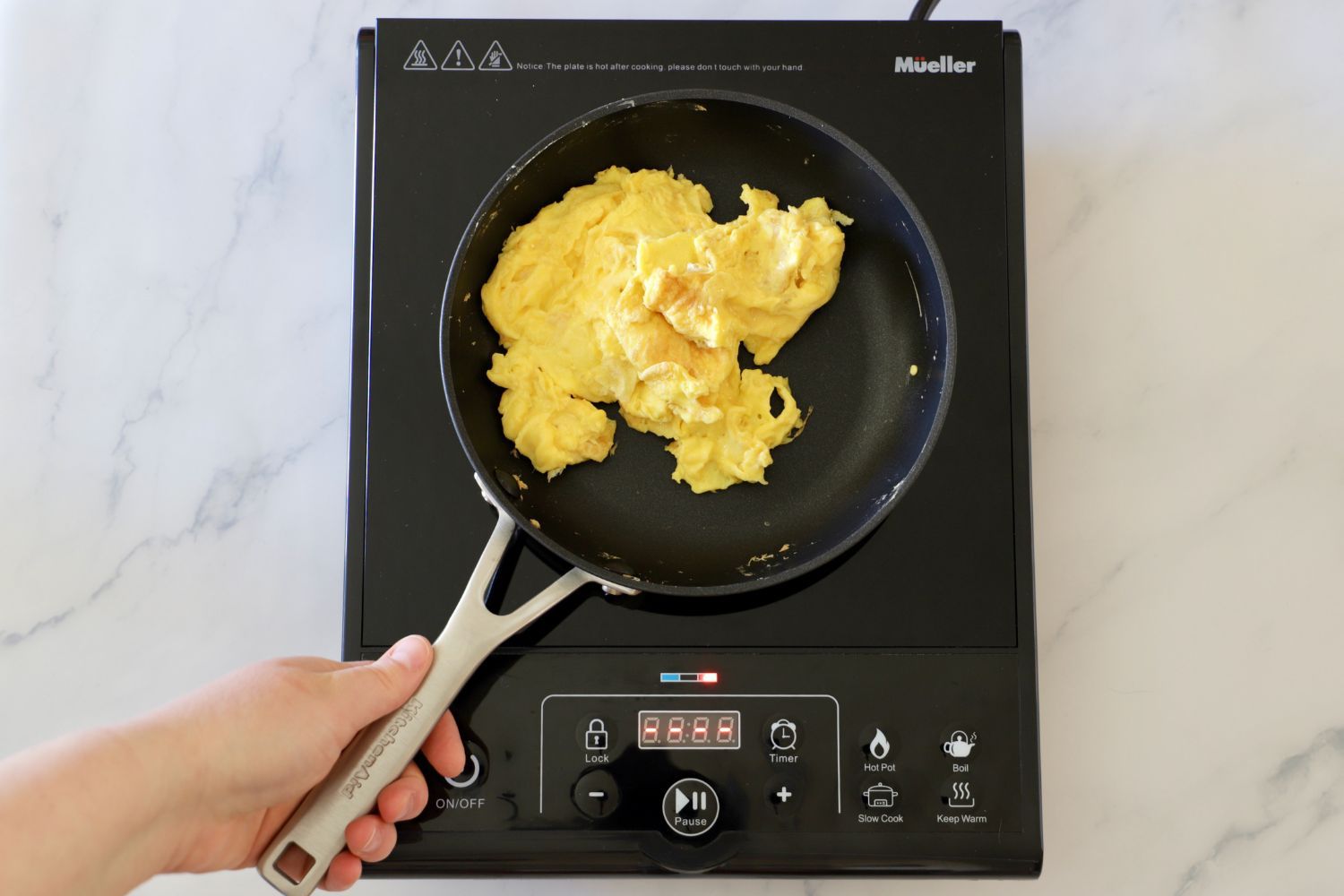 scrambling eggs in a nonstick pan on an induction burner