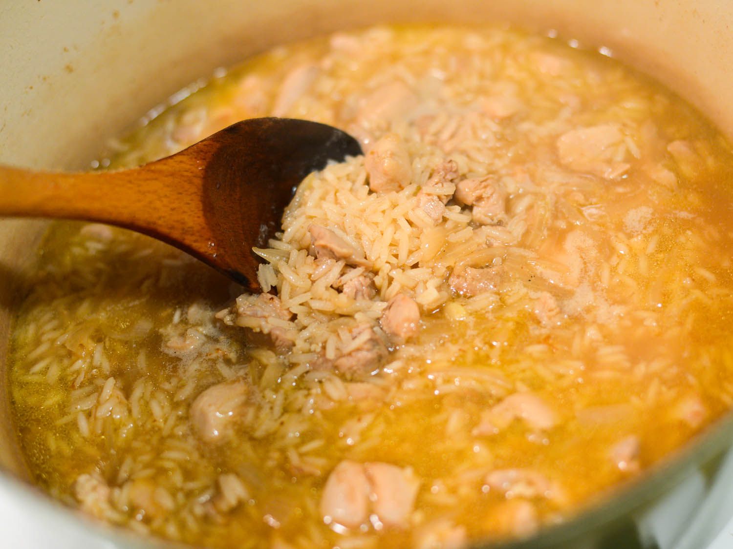 作者在烹饪过程中搅拌arroz caldo。米粒开始变饱满了。