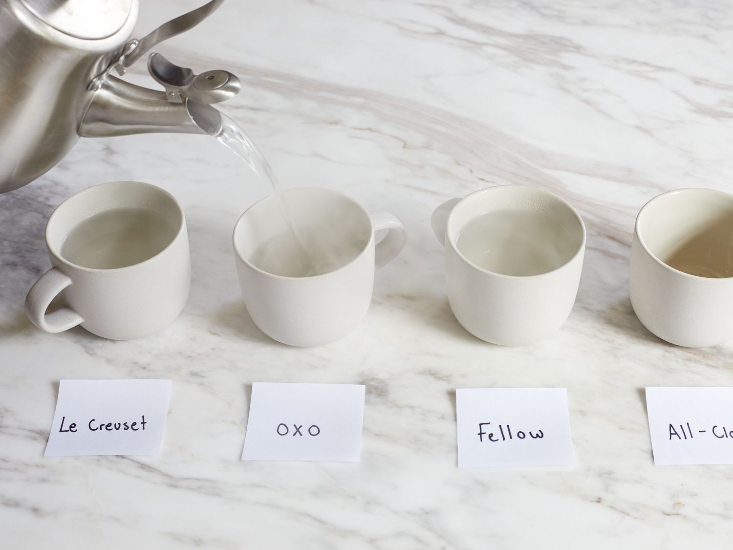 The OXO kettle pouring water into a small mug