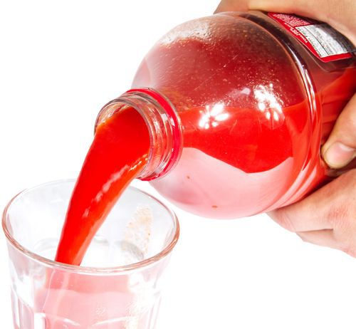 Pouring tomato juice into a glass.