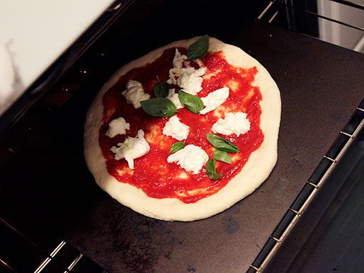 烤箱里的钢架上烤着一块未煮熟的披萨