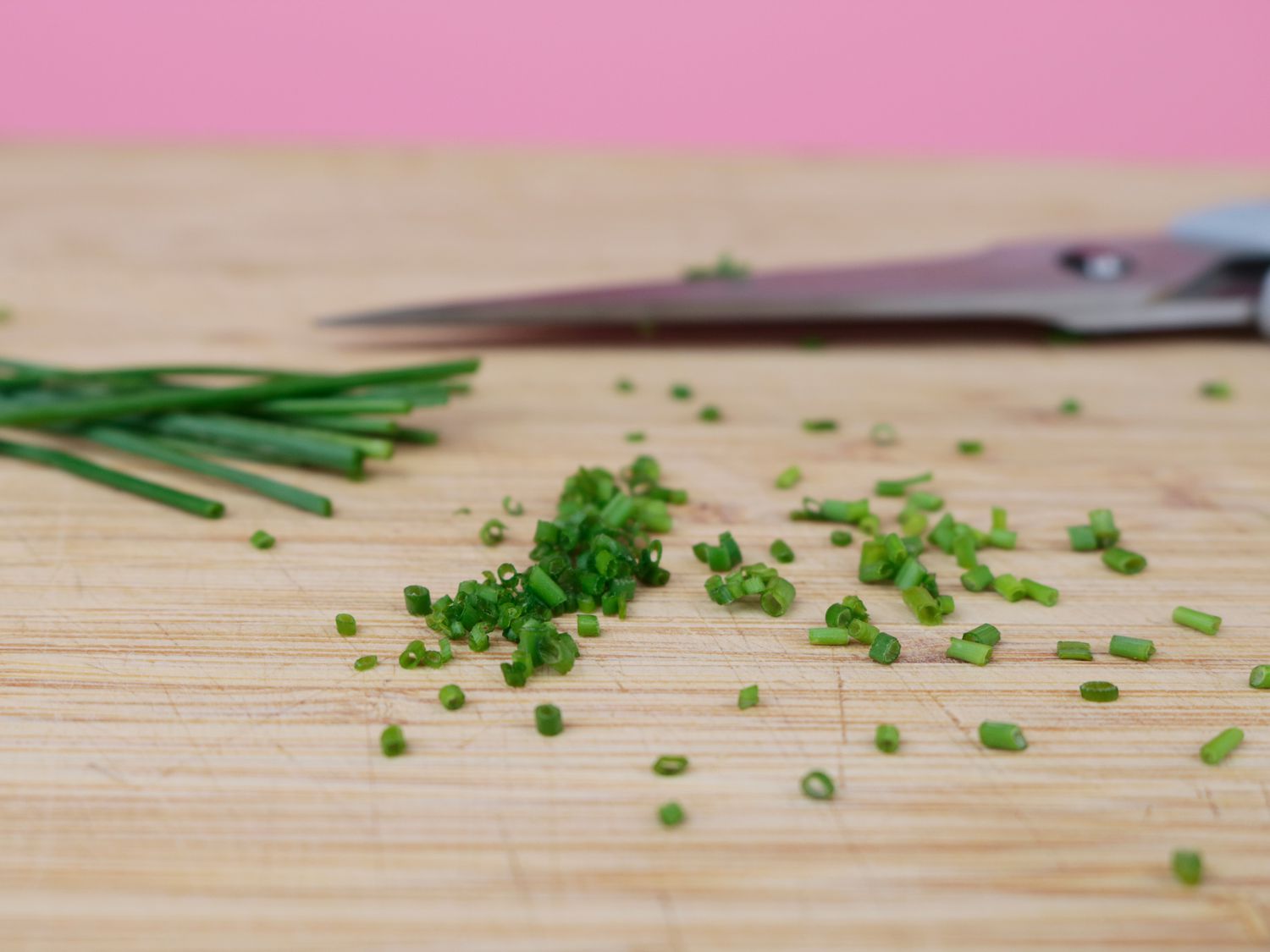 a close up shot of snipped chives with kitchen shears in the background