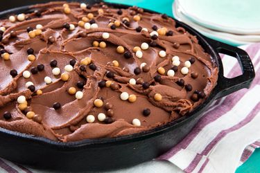 Closeup of chocolate skillet cake with milk chocolate frosting, topped with Valrhona pearls.