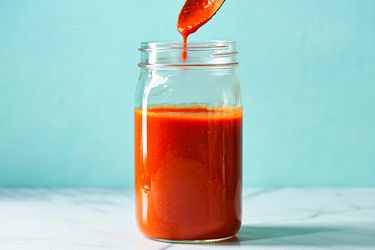 Finished sauce in a sealed glass jar with a spoon holding some of the mixture