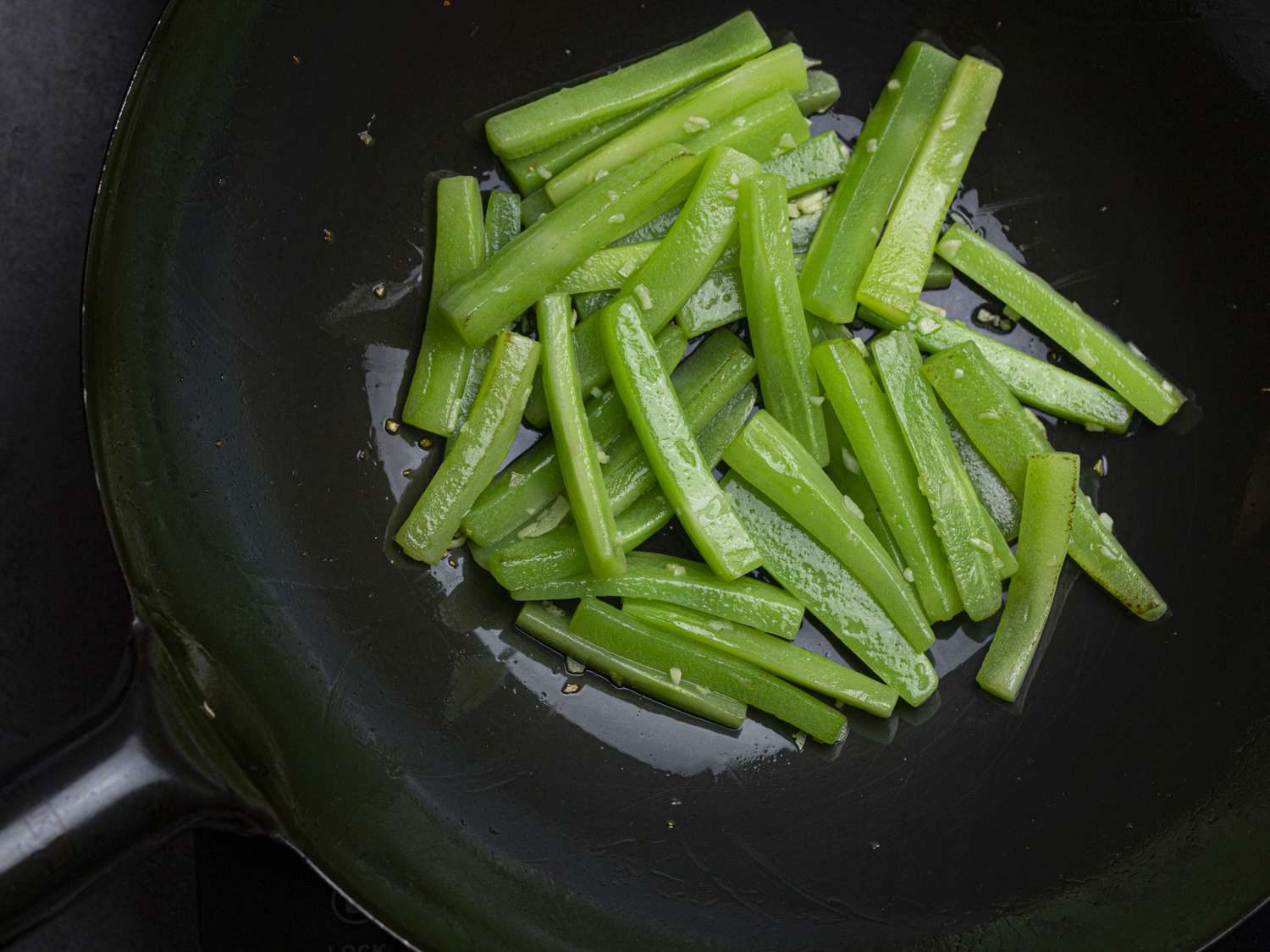 greens being stir-fried in a wok