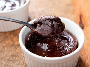 Lifting a spoonful of molten chocolate lava cake out of a ramekin
