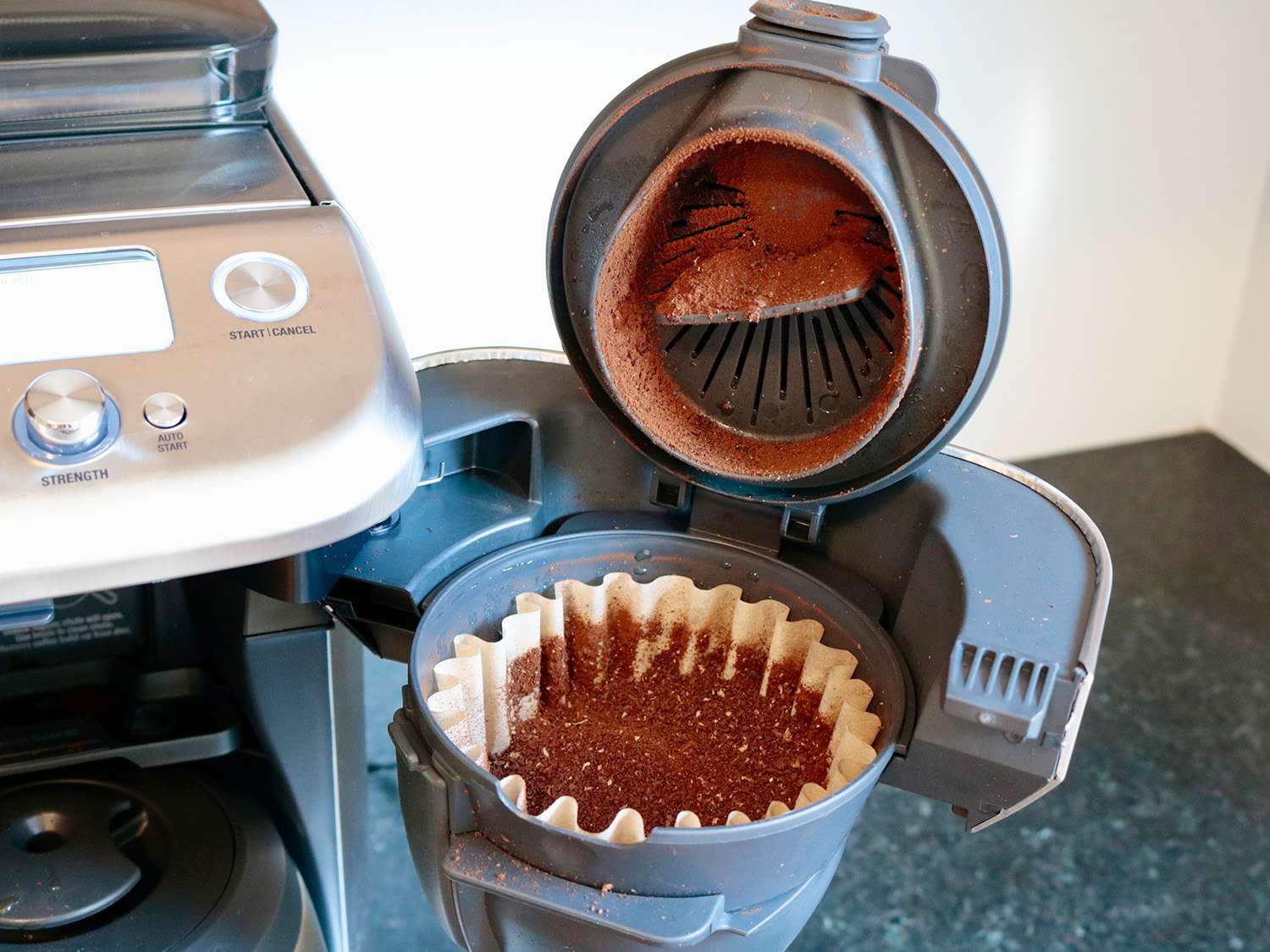 咖啡机上一个打开的过滤篮显示了过滤机里的咖啡粉