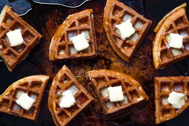 Buttermilk Vanilla waffles on a baking sheet topped with melting butter