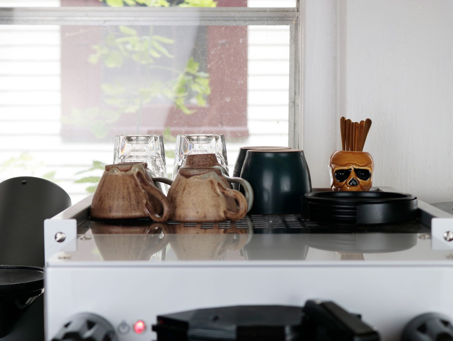 the top of a home espresso machine with a variety of cups