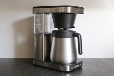 a side angle look at the oxo coffee maker sitting on a grey countertop