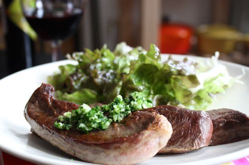 用平底锅烤牛肉心配青菜酱和沙拉，放在白色的陶瓷盘子上。