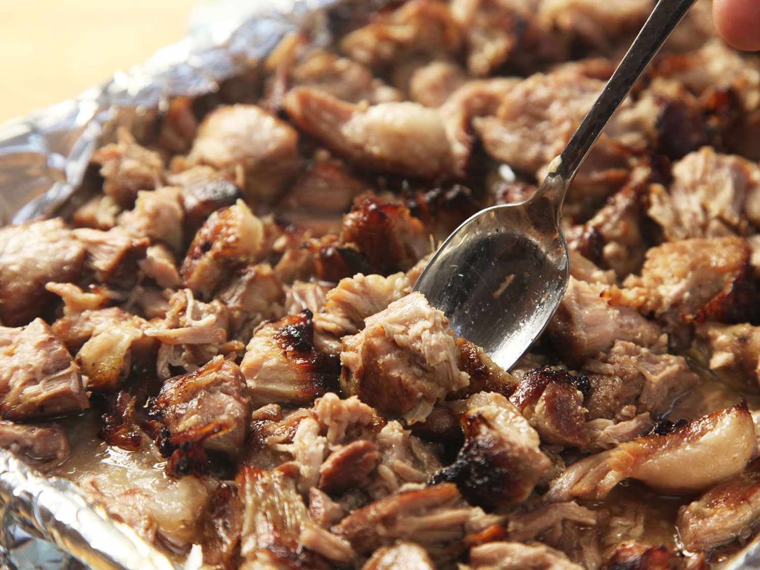 将切碎的真空蒸猪肉放在衬有锡纸的烤盘上，烤至酥脆。