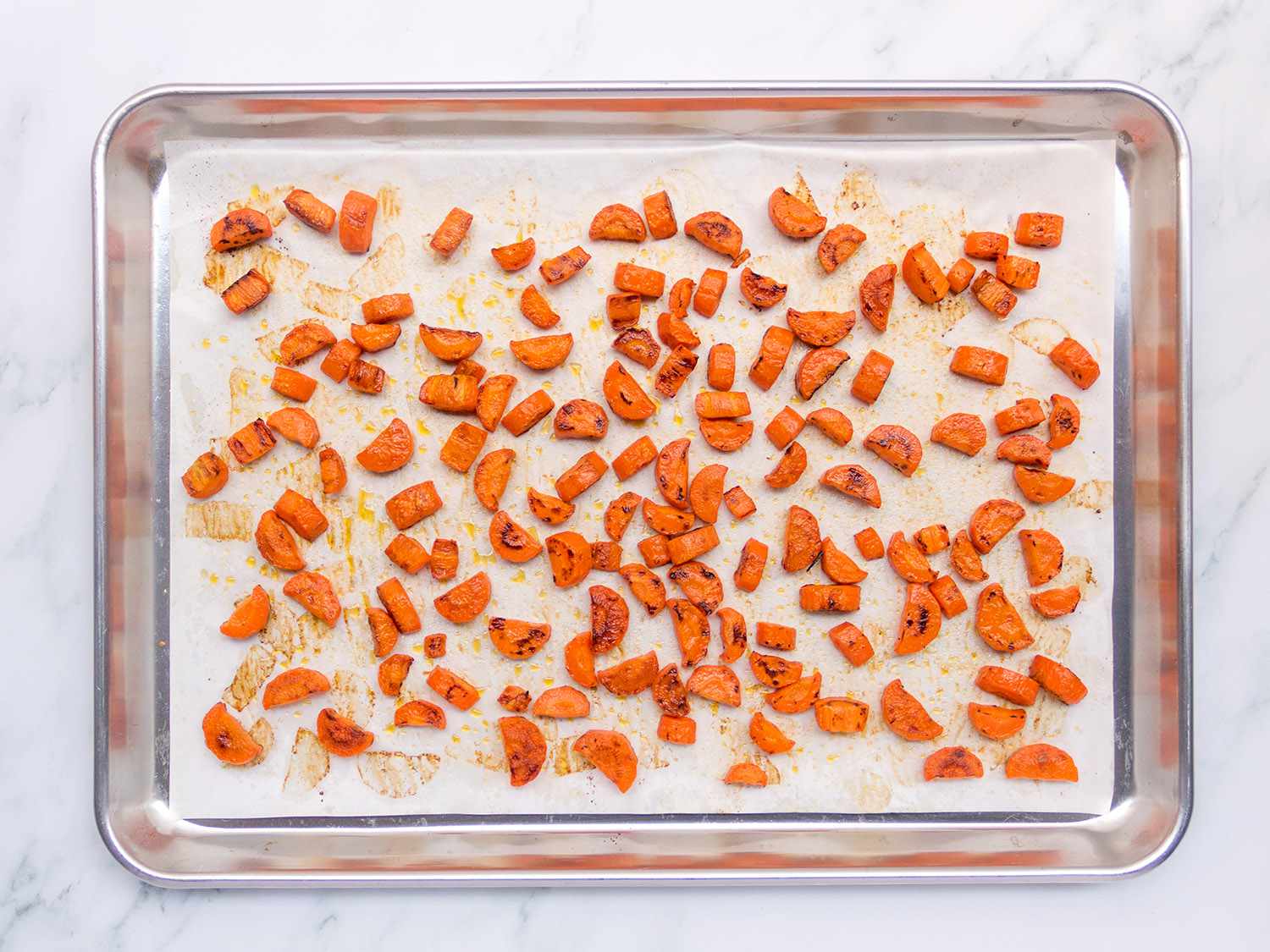 胡萝卜放在羊皮纸衬里的烤盘上。