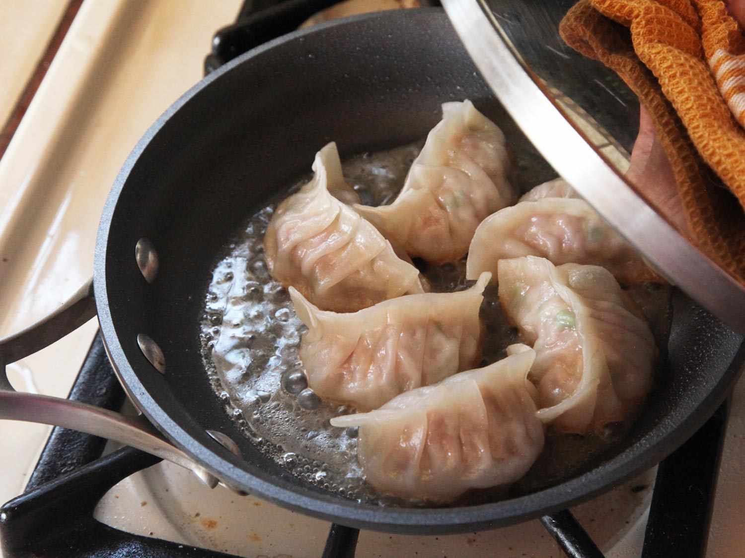 打开一锅清蒸猪肉和卷心菜的锅盖。