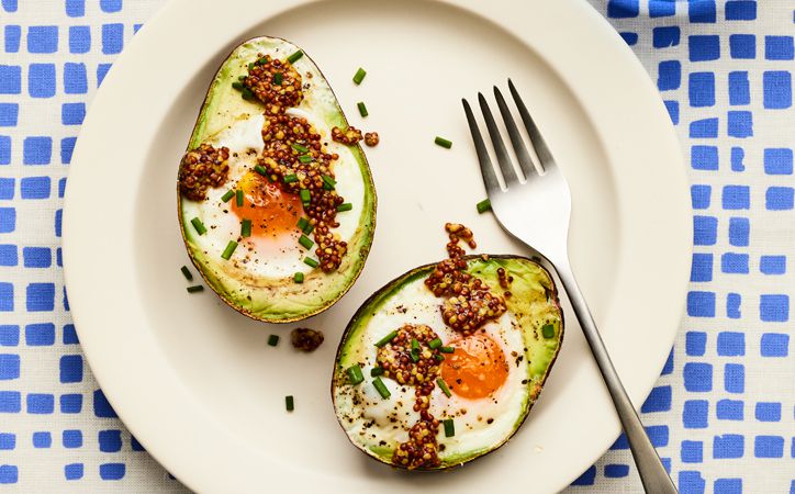 Overhead view of eggs baked in avocados