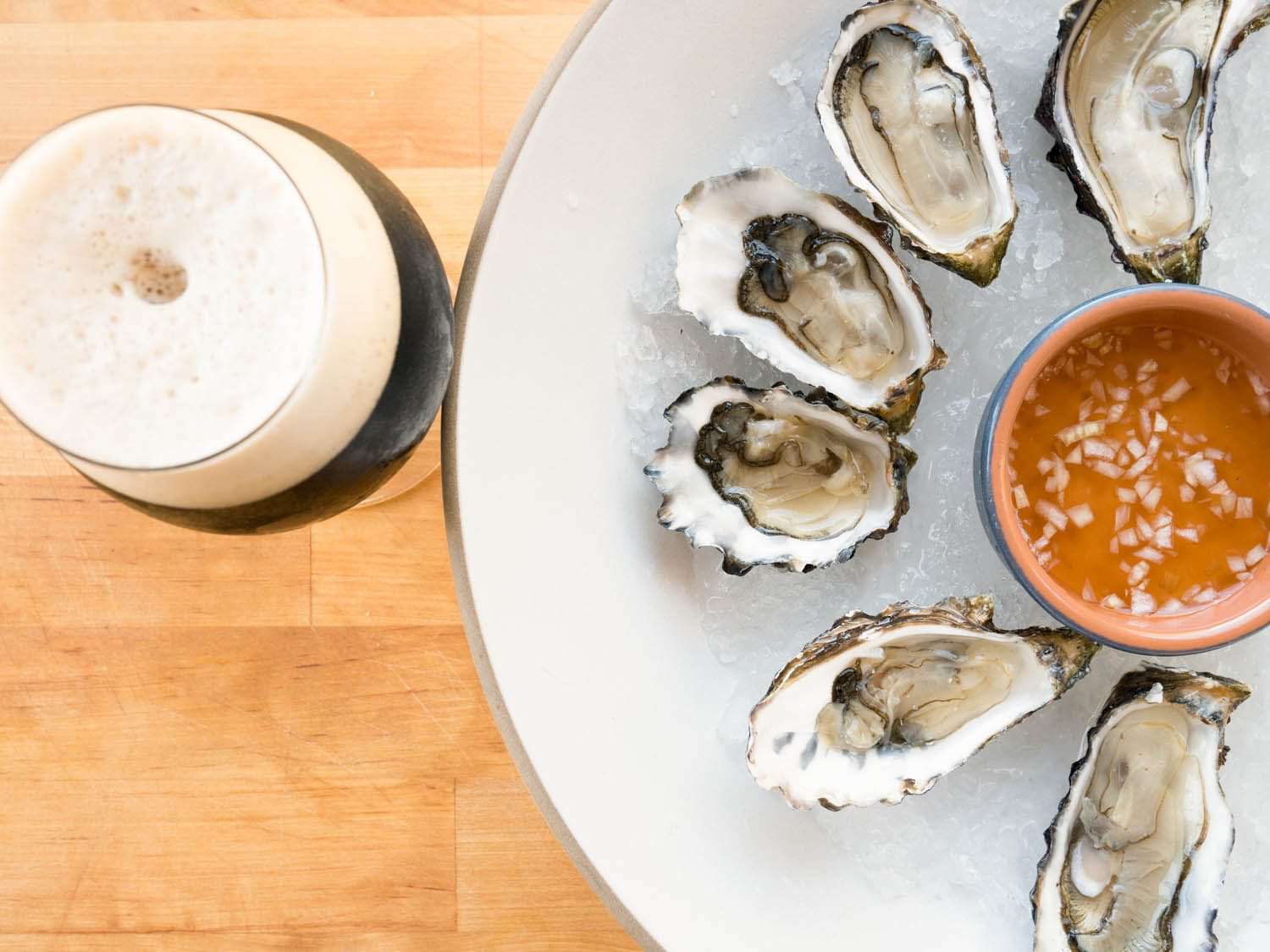 Raw oysters on the half shell with mignonette, served with a beer.